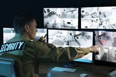 Mobil vericili güvenlik görevlisi modern CCTV 'yi izliyor. 