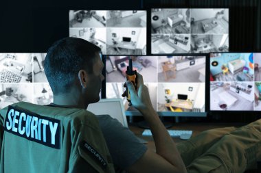 Mobil vericili güvenlik görevlisi modern CCTV 'yi izliyor. 