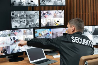 Mobil vericili güvenlik görevlisi modern CCTV 'yi izliyor. 
