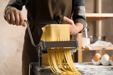 Masada makarna makinesiyle erişte hazırlayan kadın.