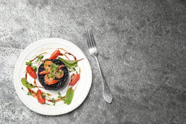 Gri masadaki deniz mahsullü leziz siyah risotto, düz. Metin için boşluk