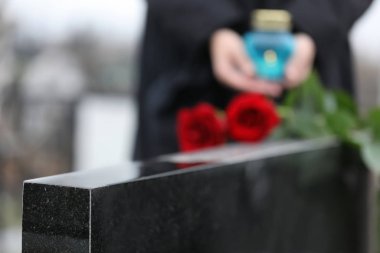 Açık havada siyah granit mezar taşı, yakın plan. Cenaze töreni.