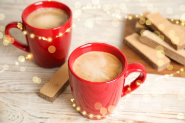 Lezzetli kahveler ve beyaz ahşap masada gofretler.