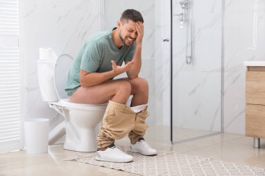 Tuvaletteki hemoroitten muzdarip adam.