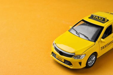 Turuncu arka planda sarı taksi modeli. Metin için boşluk