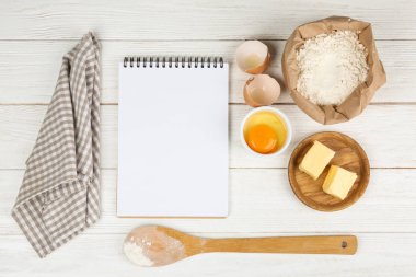 Düz kompozisyon, yumurta ve diğer malzemeler beyaz ahşap masa üzerinde, yazı için boşluk. Pasta yapmak.