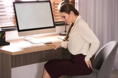 İş yerindeki hemoroitten muzdarip genç bir kadın.