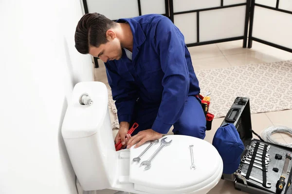 Professionele loodgieter werken met toilet kom in de badkamer — Stockfoto