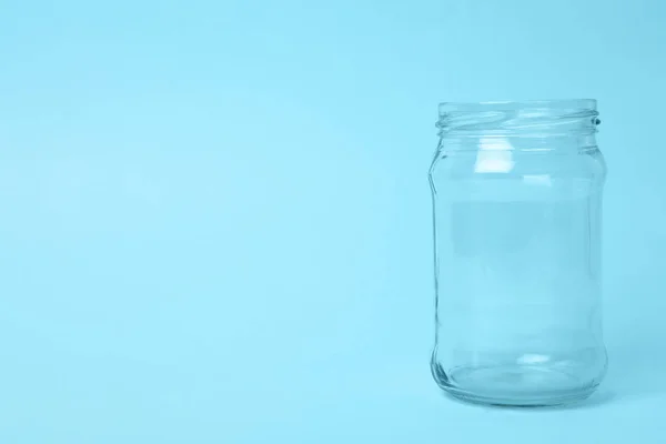 Frasco de vidro vazio aberto no fundo azul claro, espaço para texto — Fotografia de Stock