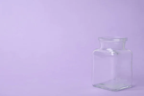 Abrir frasco de vidro vazio no fundo lilás, espaço para texto — Fotografia de Stock