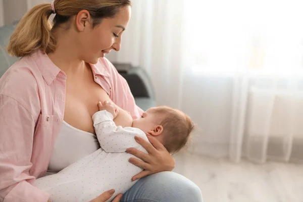 Junge Frau stillt ihr Baby zu Hause — Stockfoto