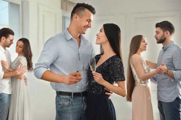 Charmant jeune couple avec des verres de champagne à la soirée dansante — Photo