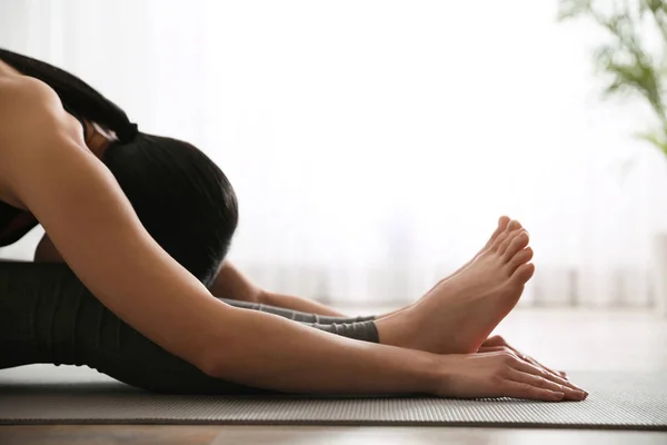 Tânără femeie care practică așezat înainte îndoiți asana în studioul de yoga , — Fotografie, imagine de stoc