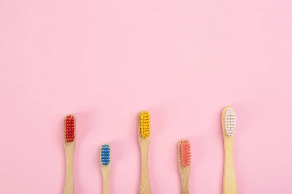 Οδοντόβουρτσες από μπαμπού σε ροζ φόντο, επίπεδες. Διάστημα — Φωτογραφία Αρχείου