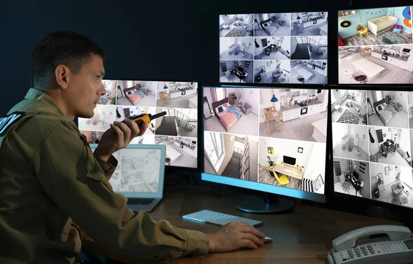 Security guard with portable transmitter monitoring modern CCTV — 스톡 사진
