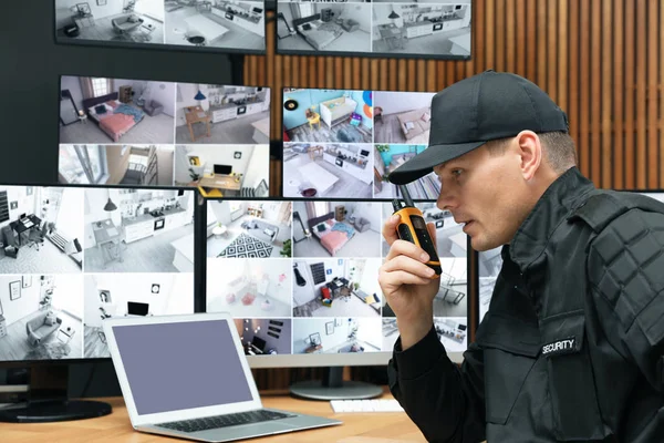 Security guard using portable transmitter at workplace in office — Stock Photo, Image