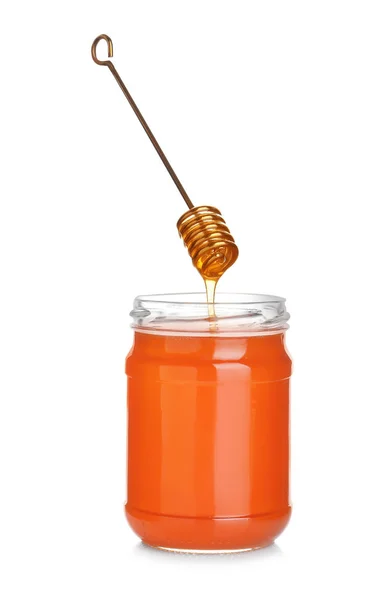 Honey dripping from dipper into jar isolated on white — Stok fotoğraf