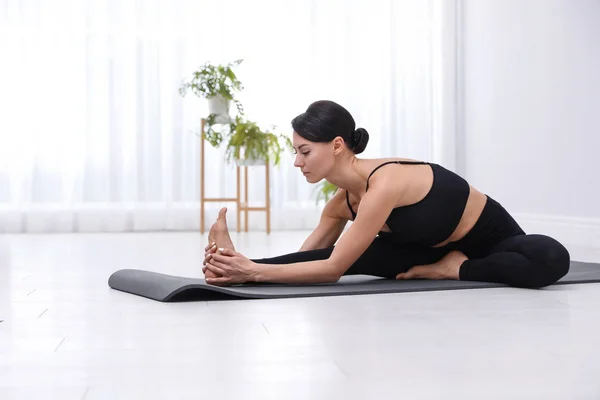 Professionele jonge acrobaat die thuis yoga beoefent — Stockfoto
