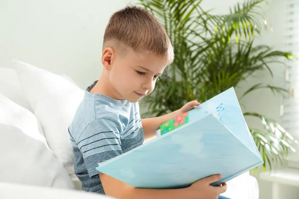 Kleiner Junge Liest Buch Auf Sofa Drinnen — Stockfoto
