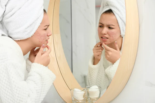 Menina adolescente com problema de acne espremendo espinha perto do espelho no banho — Fotografia de Stock