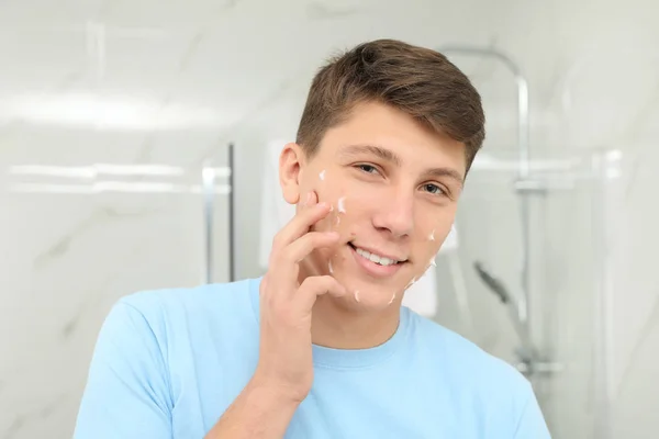 Adolescent guy avec acné problème application crème dans salle de bain — Photo