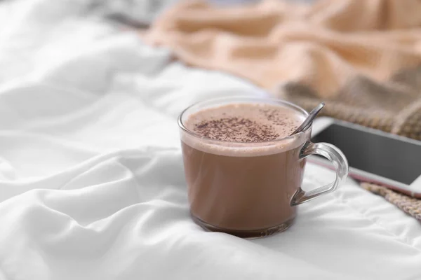 Cup of morning coffee on bed indoors