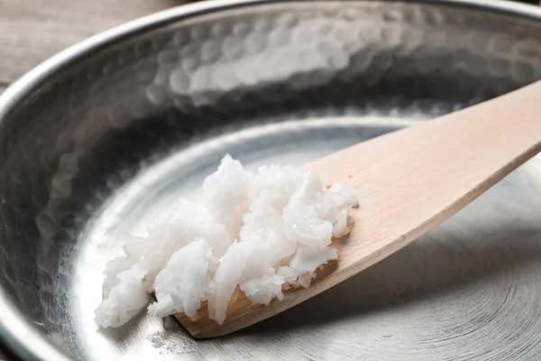 Padella con olio di cocco e spatola di legno, primo piano. Sano — Foto Stock