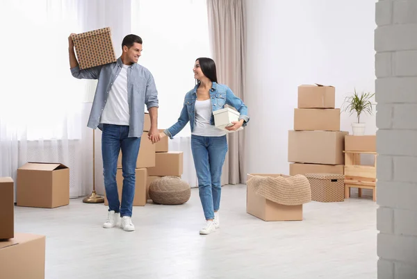 Glückliches Paar im Zimmer mit Kartons am Umzugstag — Stockfoto