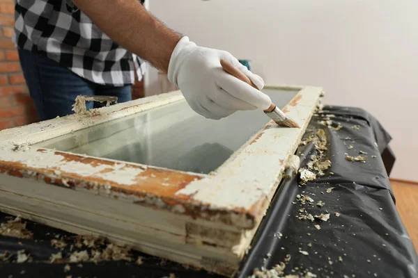 Homem reparando janela danificada velha na mesa dentro de casa, close-up — Fotografia de Stock