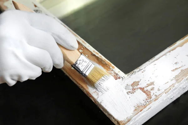 Reparador pintando janela velha à mesa dentro de casa, close-up — Fotografia de Stock