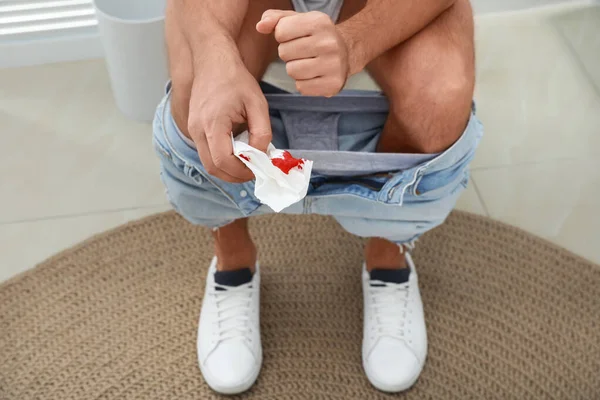 Mężczyzna Trzymający Papier Toaletowy Plamami Krwi Pokoju Odpoczynku Zbliżenie Koncepcja — Zdjęcie stockowe