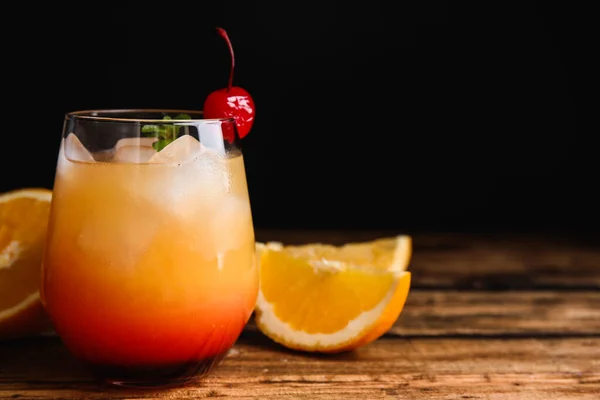 Fresh alcoholic Tequila Sunrise cocktail on wooden table