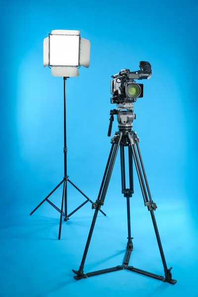 Επαγγελματική Βιντεοκάμερα Και Εξοπλισμός Φωτισμού Μπλε Φόντο — Φωτογραφία Αρχείου