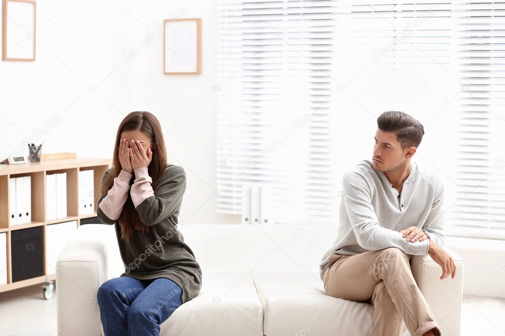 Emotional couple on sofa in psychologist's office