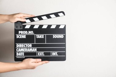 Işık duvarına karşı el çırpma tahtası tutan bir kadın, mesaj için yeri olan bir kadın. Sinema yapımı