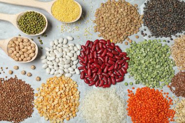 Gri mermer masa üzerinde farklı türde baklagiller ve tahıllar, düz yatak. Organik taneler