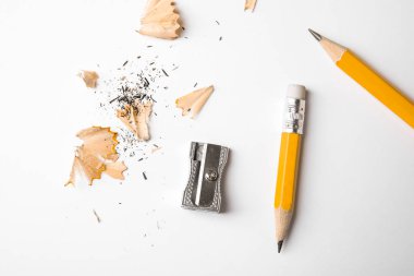 Beyaz arka planda grafit kalemler, talaşlar ve keskinleştirici...