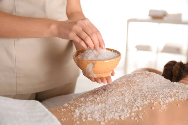 Young woman having body scrubbing procedure with sea salt in spa — Stock Photo, Image