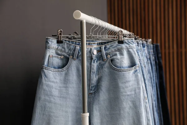 Scaffale con diversi jeans alla moda, vista da vicino — Foto Stock