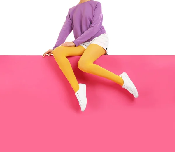 Mulher vestindo calças amarelas e sapatos elegantes sentado na cor b — Fotografia de Stock