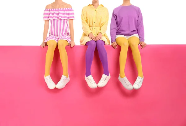 Ryhmä naisia yllään kirkas sukkahousut ja tyylikäs kengät istuu o — kuvapankkivalokuva