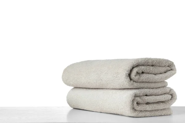 Folded fresh clean towels for bathroom on table against white ba — ストック写真