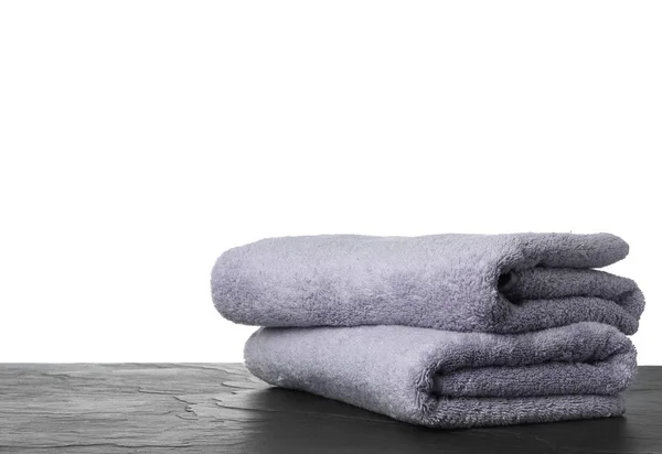 Складные чистые полотенца для ванной комнаты на столе против белого ba — стоковое фото