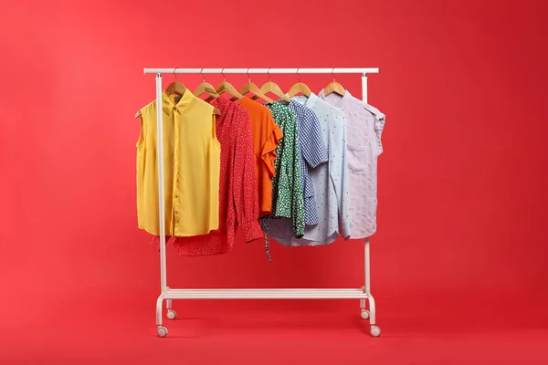 Roupas Brilhantes Penduradas Rack Contra Fundo Vermelho Cores Arco Íris — Fotografia de Stock