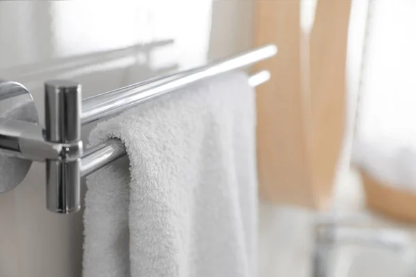Halter mit sauberem Handtuch an Lichtwand im Badezimmer, Nahaufnahme — Stockfoto