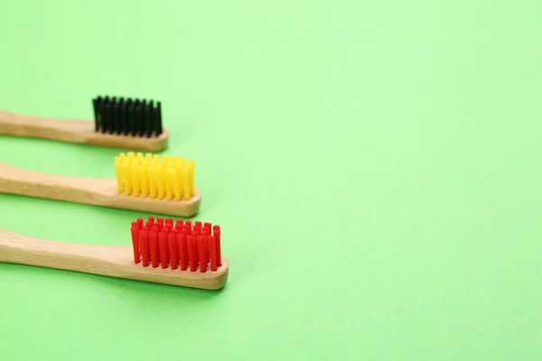 Escovas de dentes de bambu naturais em fundo verde. Espaço para texto — Fotografia de Stock