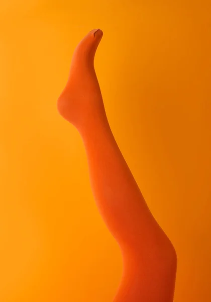 Beinpuppe Orangen Strumpfhosen Auf Farbigem Hintergrund — Stockfoto