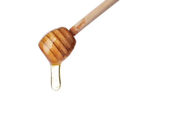 Miel goteando de una cacerola de madera aislada en blanco — Foto de Stock
