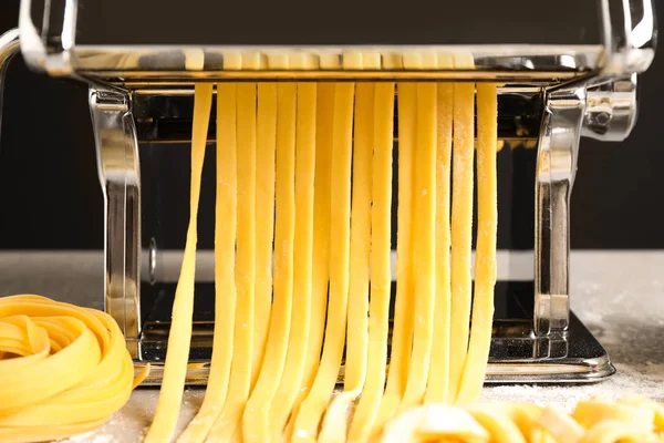 Машина для виробництва макаронних виробів з тістом на сірому столі, крупним планом — стокове фото