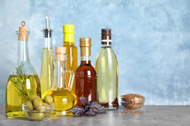Gri masadaki şişelerde farklı pişirme yağları